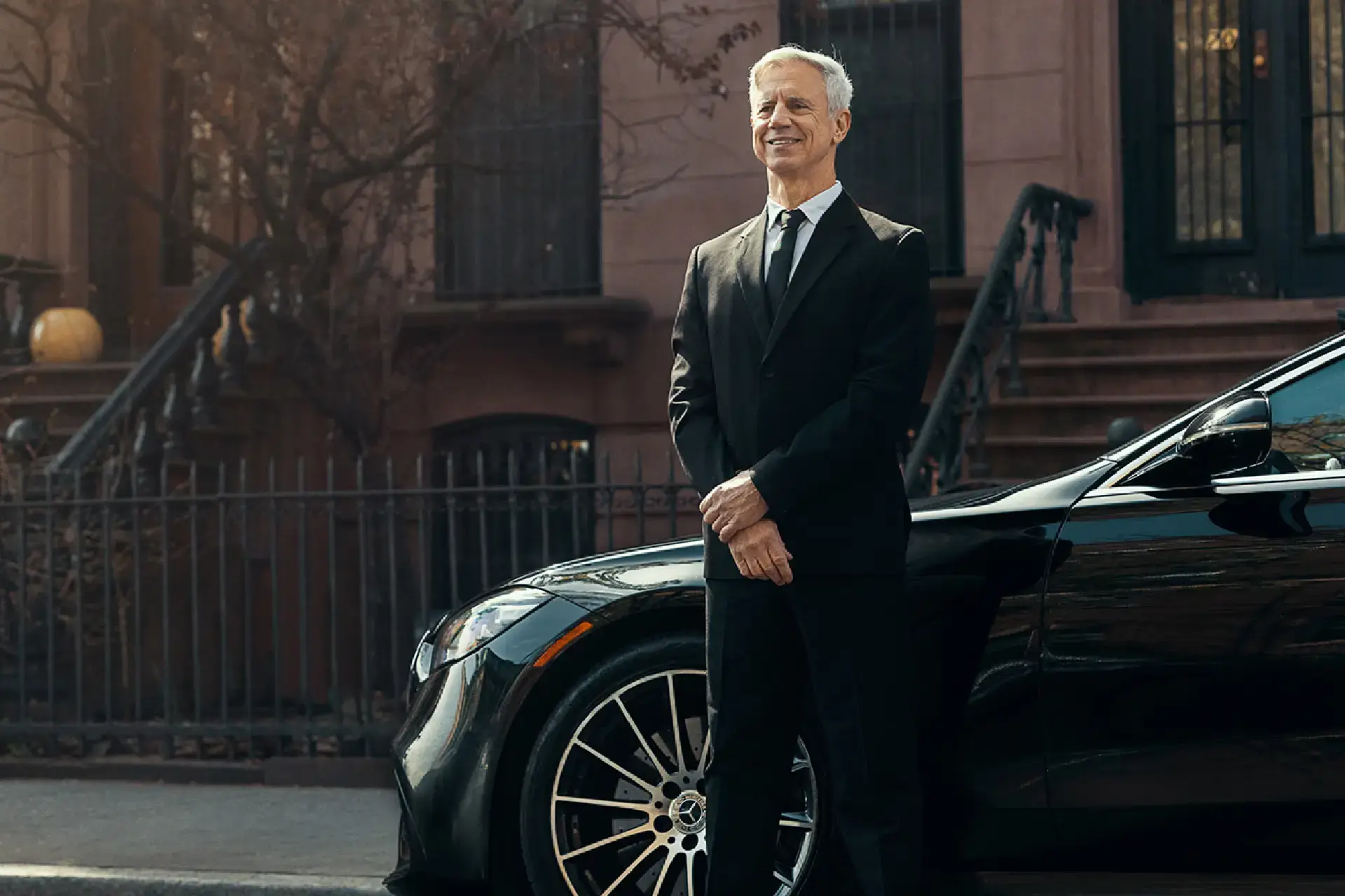 American Car Service NJ Professional chauffeur standing beside a black luxury car for American Car Service New Jersey.